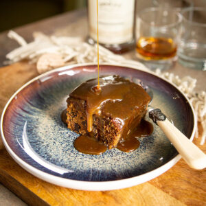 slice of sticky toffee pudding on a blue plate